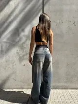 Pantalón de jean celeste de corte ancho con efecto gastado. Tiro alto y bolsillos delanteros y traseros.