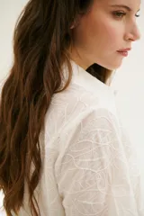 Camisa blanca de mangas cortas con estampado de hojas.