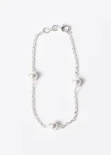 Pulsera de plata con cadena de eslabones y tres perlas blancas.