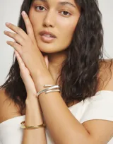 Pulsera rígida plateada con diseño de espiral abierto.