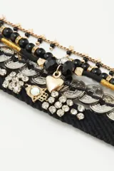 Set de pulseras con cuentas negras, monedas plateadas y apliques de strass.