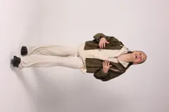 Campera bomber marrón de gamuza sintética con cuello clásico, cierre frontal con botones a presión, bolsillos laterales y charreteras en los hombros.