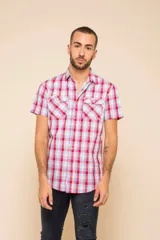 Camisa de manga corta con estampado a cuadros en tonos rojo, celeste y blanco. Tiene cierre con botones y dos bolsillos con solapa en el pecho.