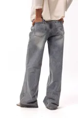 Jean de corte wide leg y tiro medio, con efecto lavado y apliques de brillos distribuidos en toda la prenda.