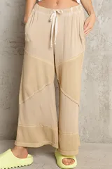 Pantalón palazzo color beige con cintura elástica ajustable con cordón y diseño patchwork con paneles de tejido waffle.