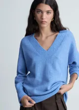 Sweater color beige de tejido de punto con cuello en V y corte oversize.