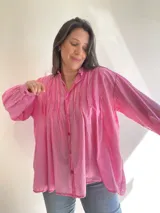 Camisa azul de algodón, corte amplio, con cuello mao, mangas largas con puños abotonados y cierre frontal con botones.