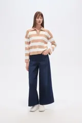 Sweater de tejido de punto, holgado, con rayas horizontales anchas en blanco y negro. Presenta cuello polo con escote en V y mangas largas.