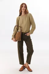 Blusa de manga larga color beige, con corte suelto y detalle de costura.