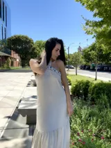 Vestido largo color crudo, con escote halter y detalle de crochet en el cuello.