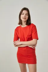 Vestido mini rojo de algodón, corte ajustado, con cuello redondo y detalle de nudo en la cintura con abertura en el abdomen.