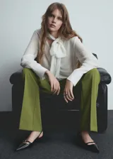 Pantalón de vestir verde oliva, de tiro alto, corte acampanado y bolsillos laterales.