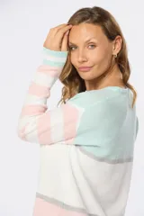 Buzo de tejido fino color beige con rayas horizontales azules y blancas, confeccionado en algodón.