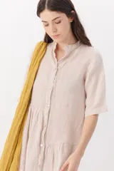 Vestido blanco de lino con cuello mao, manga corta y corte evasé.