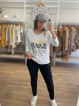 Remera negra de algodón con estampado de animal print en dorado, plateado y gris.