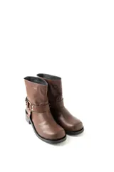 Bota corta de cuero marrón, con caña baja, base de 1,5 cm y taco de 2,5 cm. Presenta una correa con hebilla metálica alrededor del tobillo.
