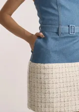 Vestido corto strapless con cuerpo superior de denim con cinturón y falda de tweed en tonos crudos.