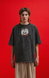 Remera oversize de algodón premium, color gris oscuro con efecto nevado (acid wash), con estampa frontal de calaveras inspiradas en Disney y texto "CHILLED BY BONE".