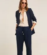 Pantalón fluido color verde oliva confeccionado en viscolino, con cintura elástica, lazo, pliegues y bolsillos.