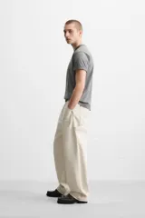 Pantalón de jean color crudo, corte relaxed fit, con bolsillos frontales y traseros tipo parche. Tiene tira multifunción y bolsillo tipo parche en las piernas.