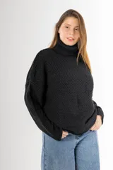 Sweater negro tejido en punto arroz, con cuello alto, mangas largas y silueta holgada.
