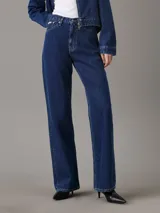 Pantalón de jean azul oscuro, de tiro alto, corte bootcut, cinco bolsillos y cierre con cremallera.