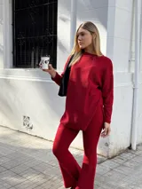Sweater rojo de tejido acanalado, corte suelto y tajos a los costados.