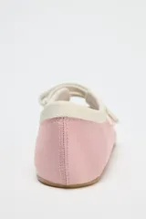 Zapato tipo bailarina deportiva color rosa con efecto satinado, puntera redondeada y doble tira con ajuste adhesivo.