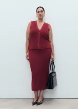 Chaleco de tejido de punto fino color rojo oscuro (vino), con cuello de pico, tirantes anchos y cierre frontal con botones.