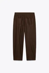 Pantalón bombacho color beige de lino, con cintura elástica, bolsillos frontales y bolsillos de parche en la espalda.