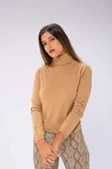 Sweater de cuello alto color beige, de tejido de punto fino.