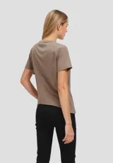 Remera color beige con cuello redondo y mangas cortas con frunce. Presenta una banda horizontal de encaje en el frente.