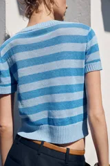 Top de punto celeste con rayas horizontales en azul. Tiene cuello redondo y mangas cortas.