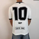 Remera tejida blanca con cuello y puños negros, con el número 10 estampado en la espalda en color negro. Incluye las siglas VCP y el rango de años 2015-infinito.