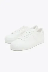 Zapatillas deportivas blancas con detalle de pespuntes en el cuerpo y suela de plataforma.