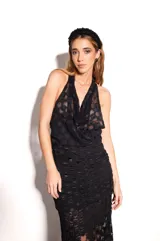 Top negro de encaje con cuello halter y corte fluido en el pecho.