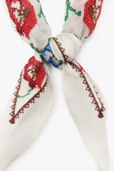 Bandana blanca de algodón con bordado de flores rojas y azules.
