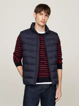 Chaleco acolchado Tommy Hilfiger color azul marino, con cuello alto, cierre de cremallera y dos bolsillos laterales.
