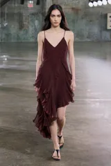 Vestido midi de viscosa color borgoña, con escote en V, tirantes finos ajustables, bordados a tono y volantes en el mismo tejido. El bajo es asimétrico.