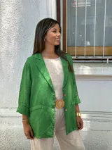 Blazer de mujer color verde vibrante, de corte relajado y manga larga remangada. Presenta solapas de muesca y cierre frontal con dos botones.