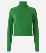 Blusa de punto color blanco, con cuello alto, manga larga y diseño liso.