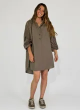 Vestido corto color ocre, con cuello mao, mangas largas abullonadas con detalle de encaje y corte evasé.