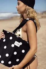 Bolso tipo tote bag de lona color crudo con estampado de lunares negros. Posee dos asas de hombro y una etiqueta blanca con el logo "AIRE" en el centro.