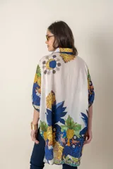 Camisa italiana de viscosa estampada con diseño abstracto en tonos azul, amarillo y verde sobre fondo natural, de corte irregular y mangas 3/4.