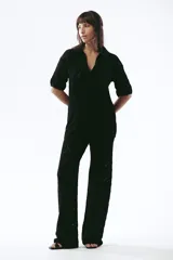 Pantalón de tejido de punto color crema, de tiro alto y pierna ancha, con diseño calado de rombos.