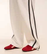 Pantalón wide leg de helanca color blanco, con cintura elástica ajustable con cordón, bolsillos laterales, raya lateral negra y bajo ajustable.