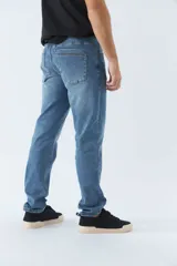 Pantalón jean azul de corte recto con roturas en las rodillas, tiro medio, logo bordado y presillas para cinturón.
