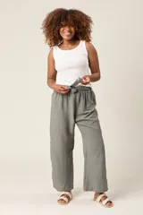 Pantalón palazzo color verde oliva, de tiro alto, con cintura elastizada y lazo ajustable.