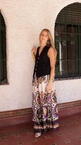 Pantalón palazzo de seda color crema con estampado abstracto en tonos violeta, negro, marrón y dorado. Tiene bolsillos laterales y cintura elástica.