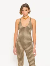 Top color beige con estampado geométrico negro, escote halter y espalda descubierta.